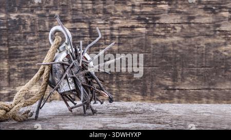 Two-way steel search magnet with rusty nails and old rope on wooden table, text place Stock Photo
