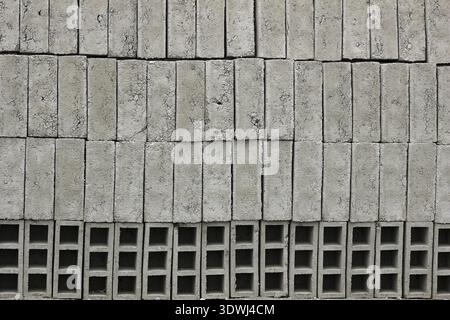 Gray handmade bricks are stacked for sale at an outdoor brickyard in Otavalo, Ecuador Stock Photo