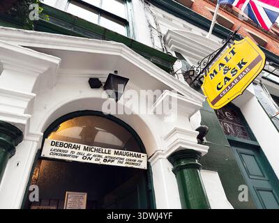 Manchester, UK - January 30, 2026: Historic Manchester The Vine Inn pub facade with bright yellow sign, arched doorway, and flag accents. Stock Photo