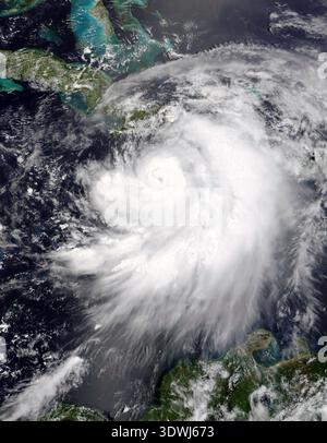 This satellite image from July 7, 2005, captured Hurricane Dennis as it strengthened over the Caribbean Sea, showing its distinct eye and spiral arms. The powerful storm is seen threading its way between Jamaica and Haiti, on a direct course for Cuba. Stock Photo