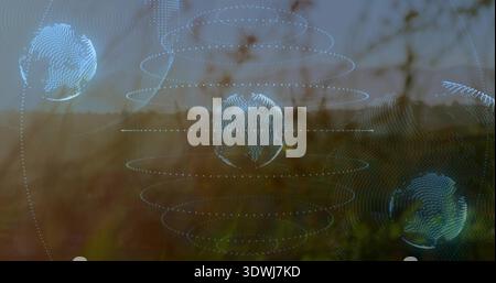 Hovering central wireframe globe projecting dotted orbital rings over grassy field, sun flare Stock Photo