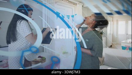 Decorating two women in white polka-dot and green dresses writing chalkboard tying balloon bunting Stock Photo