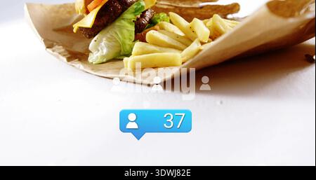 Displaying burger and fries on white tabletop with crumpled paper, three grey icons, blue 37 bubble Stock Photo