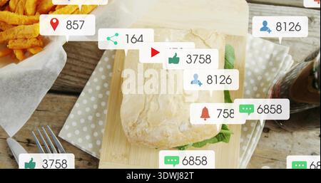 Displaying ciabatta sandwich with lettuce on polka-dot napkin on wooden table, showing social icons Stock Photo