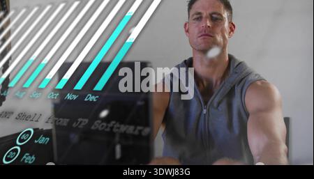 Facing man wearing sleeveless gray hoodie, viewing teal bars on monitor in home office, copy space Stock Photo