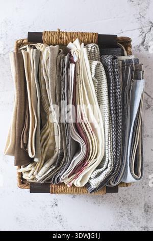 Kitchen textile. stack of fabrics in different colors and textures, close-up. Kitchen towels on white background. Many fabric kitchen napkins in a wic Stock Photo
