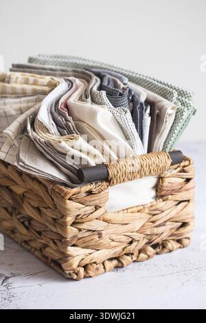 Kitchen textile. stack of fabrics in different colors and textures, close-up. Kitchen towels on white background. Many fabric kitchen napkins in a wic Stock Photo