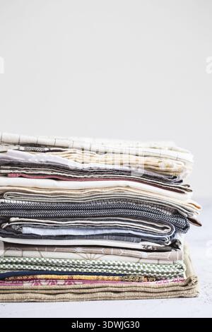 Kitchen textile. stack of fabrics in different colors and textures, close-up. Kitchen towels on white background. Many fabric kitchen napkins in a wic Stock Photo