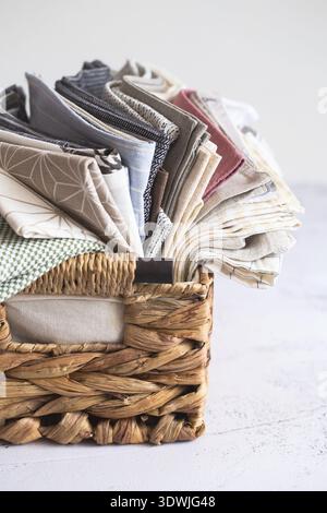 Kitchen textile. stack of fabrics in different colors and textures, close-up. Kitchen towels on white background. Many fabric kitchen napkins in a wic Stock Photo