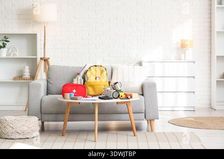Emergency backpack with necessities on table in living room interior Stock Photo