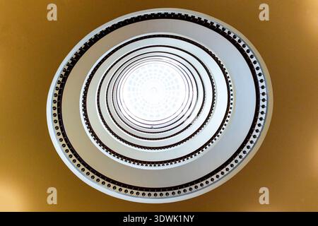 A stunning spiral staircase viewed from below, creating a mesmerizing geometric pattern. Stock Photo