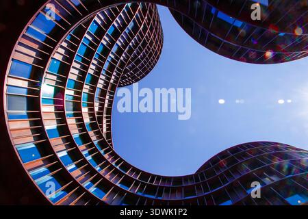 A striking view of contemporary curved architecture against a clear blue sky. Stock Photo