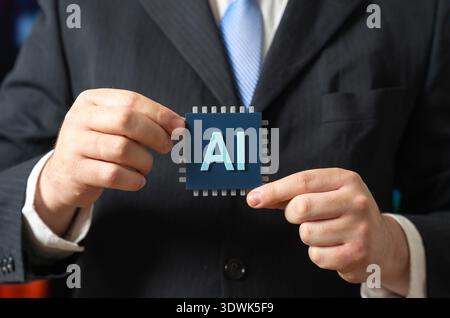 A businessman holds an AI chip. Implementing AI technologies in business. Investing in innovation. Digital transformation, automation strategy and future-ready corporate development. Stock Photo