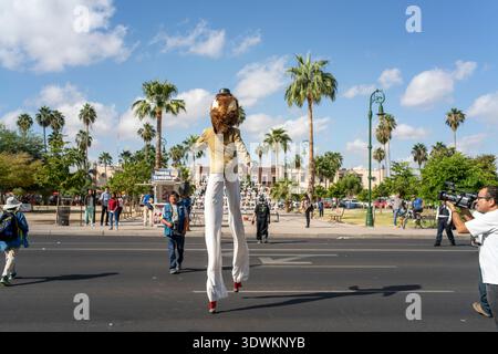Costumed person on stilts crossing street in Mexico Stock Photo