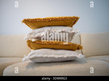 Stack of decorative pillows on sofa in cozy Scandinavian living room Stock Photo