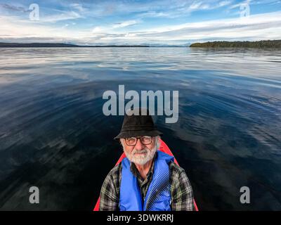 Close-up portrait of a senior man wearing a lifejacket kayaking in the ocean, Alert Bay, Cormorant Island, British Columbia, Canada Stock Photo
