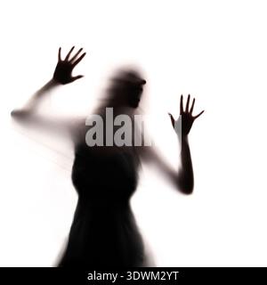 Female silhouette behind translucent surface expressing fear, anxiety and isolation, symbolic conceptual image representing mental health. emotional Stock Photo
