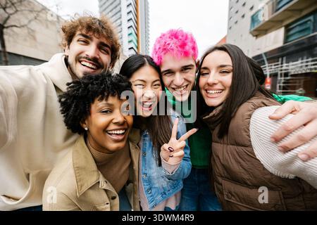Young diverse friends taking group selfie on street Stock Photo