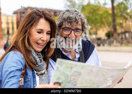 Smiling senior couple reading a map while traveling in Barcelona.  Stock Photo
