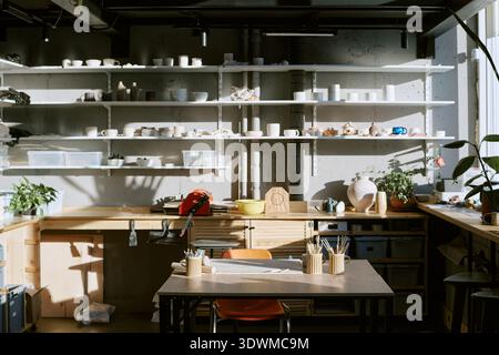 Empty Pottery Studio Workspace Displaying Sunlit Tools and Ceramic Creations Stock Photo