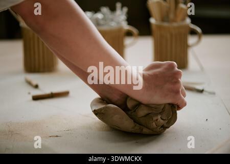Young Adult Woman Kneading Clay While Working on Pottery Project Stock Photo