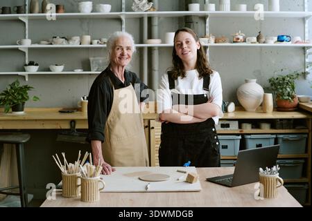 Senior Woman and Young Adult Woman Working in Pottery Studio Stock Photo