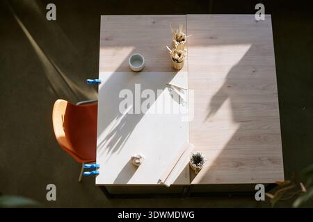 Empty Workspace with Art Supplies Awaiting Creative Activity in Sunlit Room Stock Photo