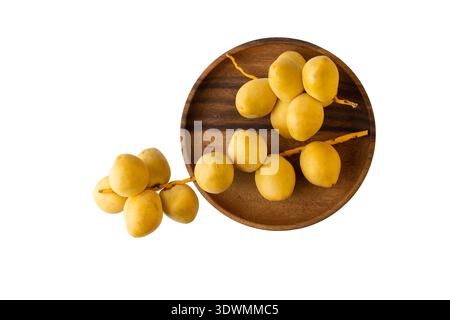 Ripe yellow dates bunches on wooden plate isolated on white background. Stock Photo