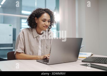 Focused Lady Reviewing Financial Data. Tranquil Woman Analyzing Detailed Financial Projections At Her Desk Stock Photo