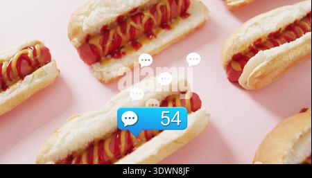 Showing central hotdog sitting in bun on pink backdrop, with blue chat bubble 54, speech icons Stock Photo