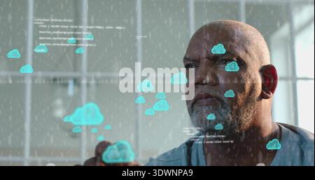 Bearded man in blue shirt using cloud icons on glass touchscreen in modern workspace, code visible Stock Photo