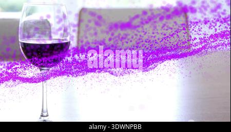 Showing stemmed glass holding dark red wine reflecting on kitchen table, purple streak, copy space Stock Photo