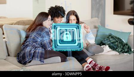 Holding tablet, three women wearing plaid shirt, socks leaning on sofa at home, showing holo lock Stock Photo