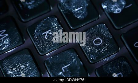 Close-up video of computer keyboard key illuminated by ultraviolet light revealing visible fingerprint on the surface. Concept of cyber security Stock Photo