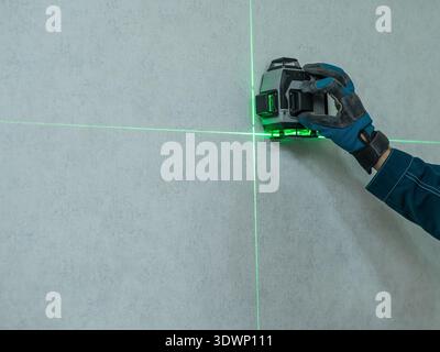 A man measures distance with a laser level.  Stock Photo