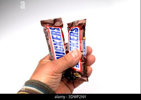 Lviv, Ukraine. February 6, 2024. Two Snickers chocolate bars in his hand.Hand holding a Snickers chocolate bar. Snickers bars are produced by Mars Inc Stock Photo