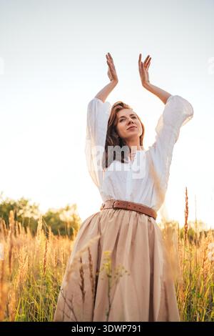 Woman nature sunlight enjoying the golden hour while smelling spring ...
