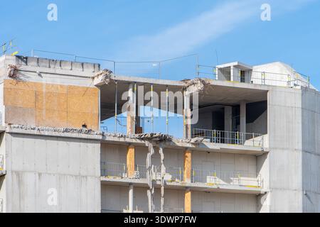 Unfinished building and construction structures against blue sky in city. Stock Photo