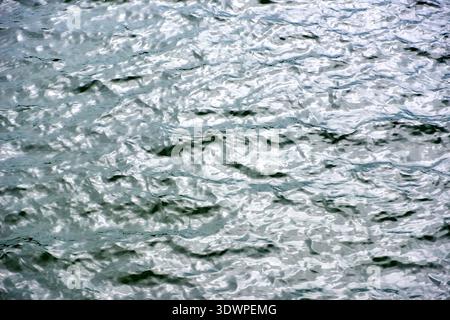 Close-up of sparkling water surface with dynamic ripples and reflections of sunlight, creating a vibrant, fluid texture. Ideal as an abstract backgrou Stock Photo