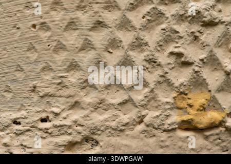 Textured beige wall with diamond pattern and subtle color variations Stock Photo