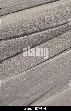 Abstract close-up of a textured surface featuring distinct parallel, wavy lines. The entire surface is covered in countless tiny, shimmering particles Stock Photo