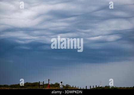A breathtaking display of undulatus asperitas clouds forming dramatic, wavy patterns across the sky above a rural landscape in Victoria, Australia. A Stock Photo