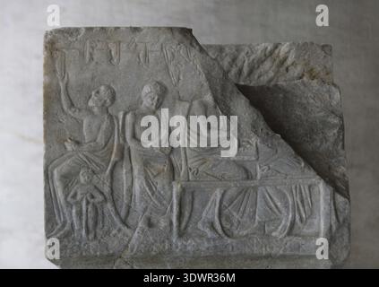 Attic votive stele with inscriptions. Relief depicting a scene from the workshop of a cobbler. Dedicated to the hero Kallistephanos by the cobbler Dionysios and his children. 4th century BC. Museum of the Ancient Agora. Athens, Greece. Stock Photo