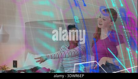 Two women chatting on bed, wearing striped top, magenta shirt, jeans, clothes, digital overlay Stock Photo