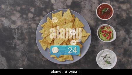 Displaying gray plate piling chips on dark tabletop, with three white bowls and blue 24 badge Stock Photo