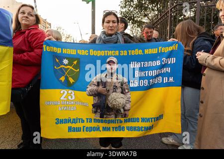 A group of people hold a blue and yellow banner with a portrait of a Ukrainian soldier in combat gear in Toulouse, Occitanie, France on February 24, 2 Stock Photo