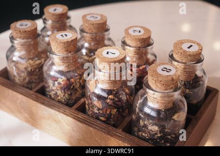 Display of jars with various herbs and spices on a table Stock Photo
