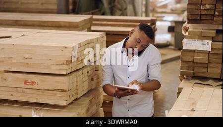 Carpentry, man and phone call in workshop with tablet, discussion and order timber for woodwork company. Manufacturing, black person and talk in Stock Photo