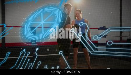 Adjusting coach fitting gloves on female boxer wearing blue tank, black shorts in ring, HUD visible Stock Photo