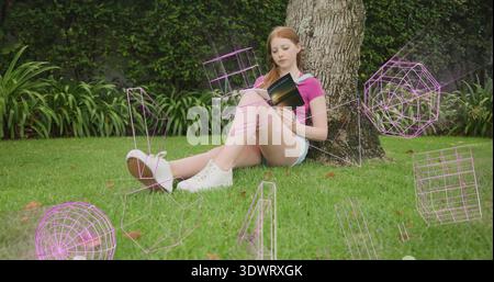 Reading woman on lawn leaning on trunk holding paperback, wearing polo and shorts, purple holograms Stock Photo
